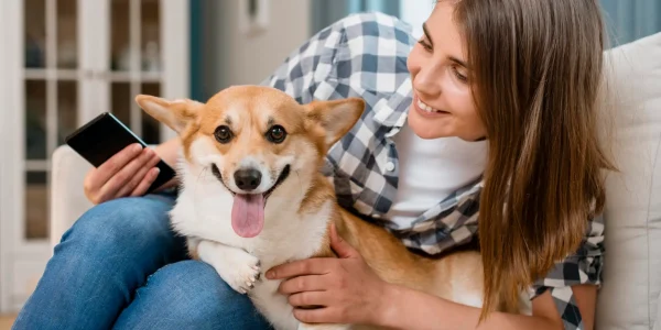 front-view-woman-holding-smartphone-dog